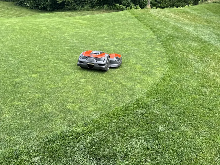 A Husqvarna Automower on a freshly striped lawn